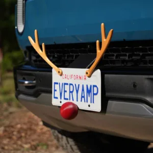 Licene plate on a car with antlers and red nose screwed on to look like Rudolph 
