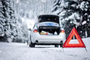 Car triangle on highway with broken car in winter
