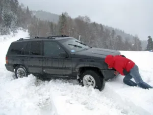 Man trying to push car out of snow