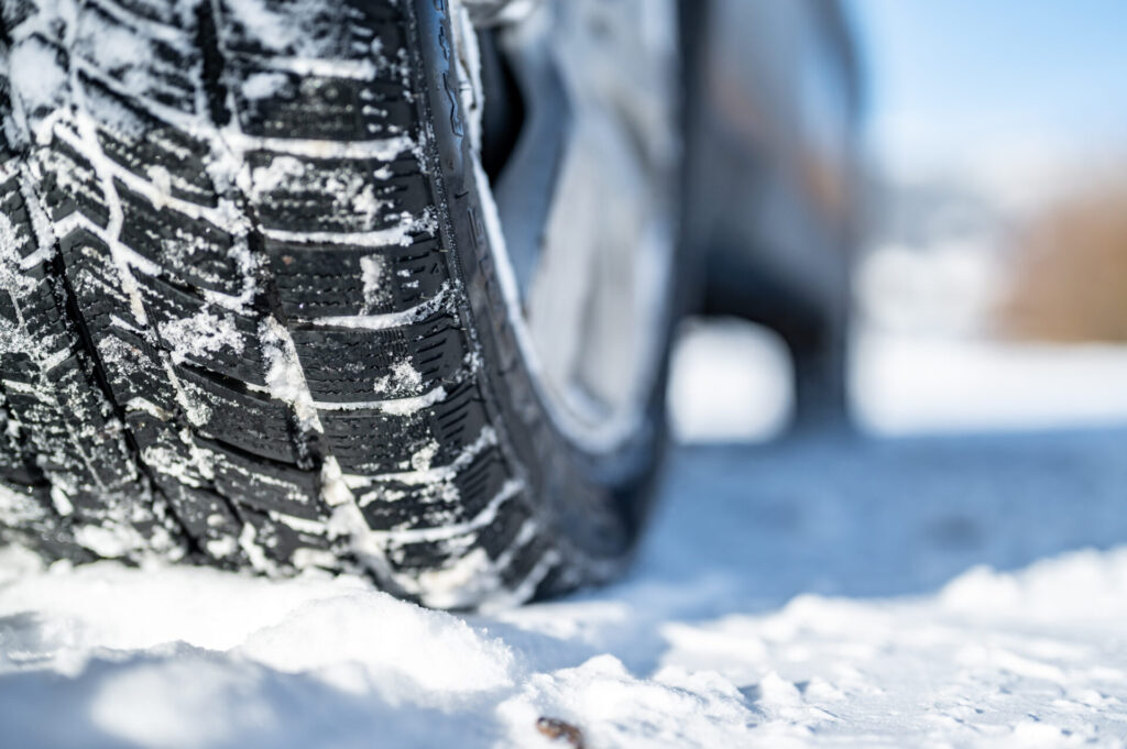 Winter tire. Detail of car tires in winter on the road covered with snow.